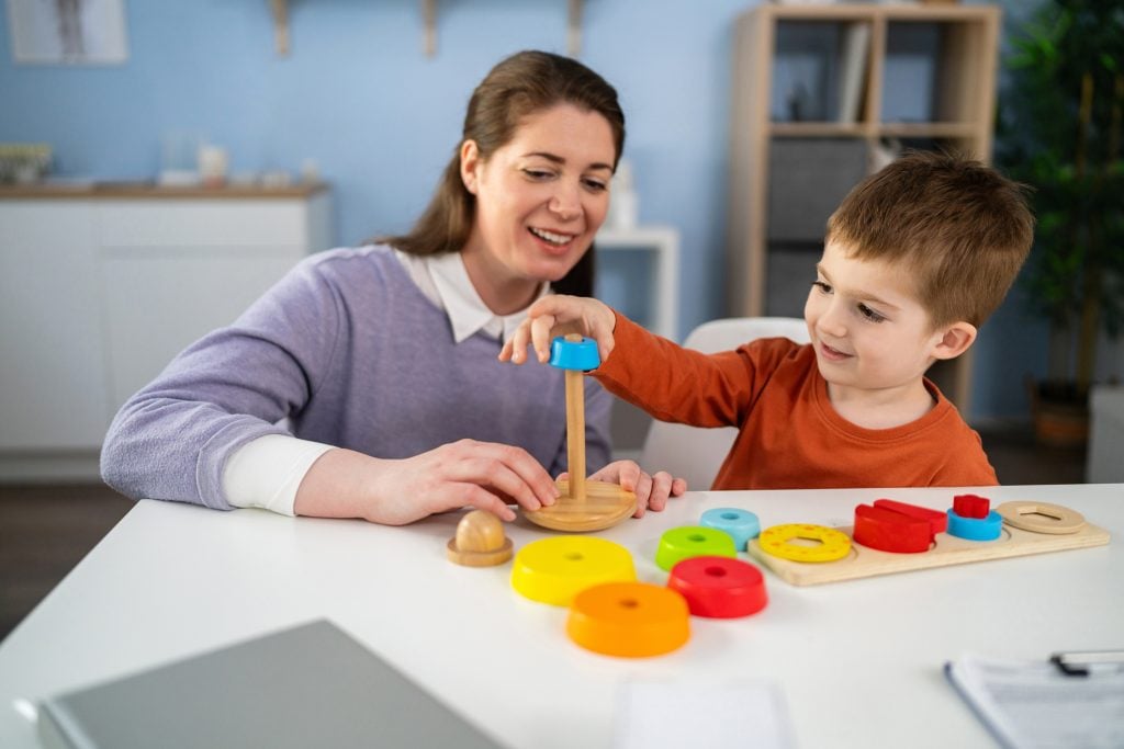 Caucasian female pediatrician examining the Caucasian boy's skills and level of development, during an annual medical check-up